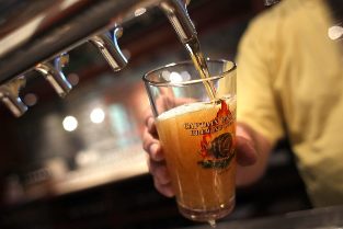 Il barista versa la birra in un bicchiere